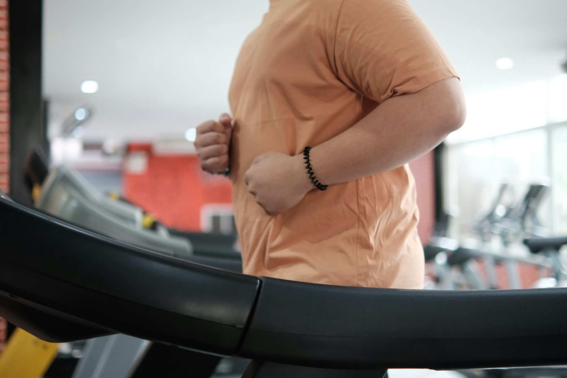 An overweight man running on a treadmill